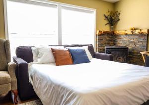 ein Schlafzimmer mit einem Bett, einem Sofa und einem Kamin in der Unterkunft The Dutch House Family Hideaway in Klamath Falls
