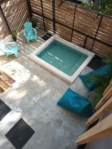 una piscina con una silla azul y un banco en Casa MONO en Santa Teresa