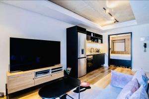sala de estar con TV de pantalla plana grande en Station House Ocean View Apartment, en Ciudad del Cabo