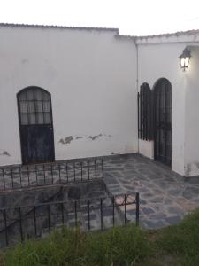 a white building with two doors and a patio at Hostel Alto Alberdi in Córdoba