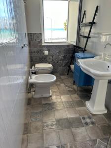 a bathroom with a toilet and a sink at AD in Capo dʼOrlando