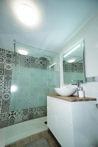 uma casa de banho com um lavatório e uma cabina de duche em vidro. em Casita Las Toscas em La Matanza de Acentejo