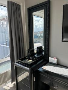 um espelho numa cómoda num quarto com uma janela em City Center Hotel em Reykjavík