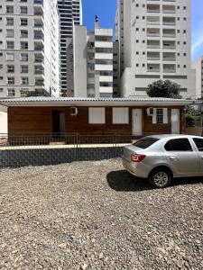 um carro estacionado em frente a um edifício com edifícios altos em Loft Lux 1 em Chapecó