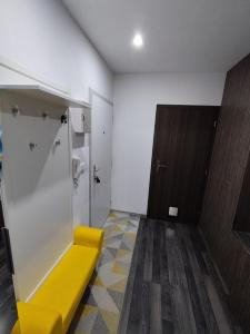 banco amarillo en una habitación con baño en Prievidza Home, en Prievidza