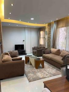 a large living room with couches and a television at 3 bedrooms flat,fully equipped in Cairo