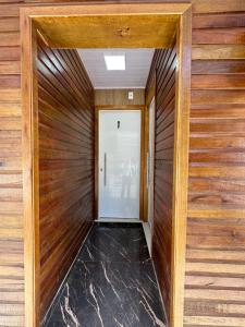 um corredor com painéis de madeira e uma porta em Loft Lux 1 em Chapecó