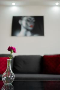 a vase with a flower in it on a table at Quiet Apartment Ruby Horizon in Bucharest