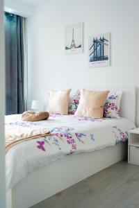 Un dormitorio con una cama blanca con flores. en Quiet Apartment Ruby Horizon, en Bucarest
