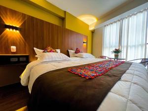 Un dormitorio con una cama grande con una manta. en Varvel residence en Cusco
