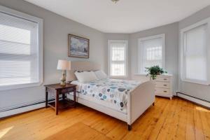 a bedroom with a bed and a table and windows at NEW! Boston Entire House Near MBTA, 3 Mi to Fenway! in Boston