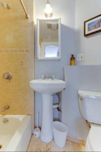 ein Badezimmer mit einem Waschbecken, einem WC und einem Spiegel in der Unterkunft NEW! Boston Entire House Near MBTA, 3 Mi to Fenway! in Boston