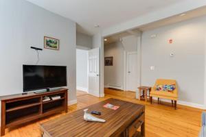 a living room with a television and a coffee table at NEW! Boston Entire House Near MBTA, 3 Mi to Fenway! in Boston