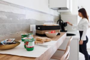 a woman standing in a kitchen with a counter with bread at Essentia Rooms & Relax in Vasto