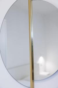 a mirror with a gold frame next to a table at Essentia Rooms & Relax in Vasto