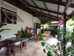 un patio con mesas, sillas y plantas en Ravehei smile relais 3 Huahine, en Haapu