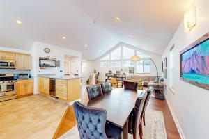 a kitchen and living room with a table and chairs at Bear Valley Mountain Retreat in Anchorage