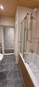 a bathroom with a tub and a shower and a sink at 2 Bed Apt, Westend, recently redecorated, 2 king beds, Close to Ninewells, Fully Equipped, Families, Contractors and Trades, Mid Stays Welcome in Dundee