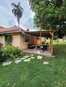 un patio trasero con pérgola y una casa en Villa sol de Samana', en Los Róbalos