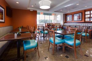 コロンビアにあるDrury Inn & Suites Columbia Stadium Boulevardの木製テーブルと青い椅子が備わるレストラン
