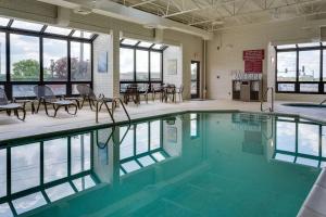 a swimming pool with tables and chairs in a building at Drury Inn & Suites Columbia Stadium Boulevard in Columbia