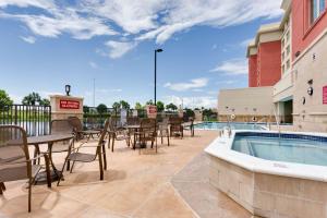 邁爾斯堡的住宿－Drury Inn & Suites Fort Myers Airport FGCU，一个带桌椅的庭院和一个游泳池