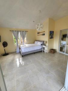 1 dormitorio con 1 cama y suelo de baldosa grande en Villa sol de Samana', en Los Róbalos