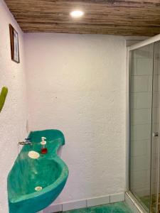 y baño con lavabo verde y ducha. en Posada Paloma, en San Agustinillo