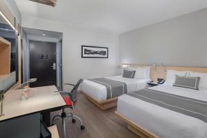 a hotel room with two beds and a desk at City Express Plus by Marriott Ciudad de M&eacute;xico Insurgentes Sur in Mexico City