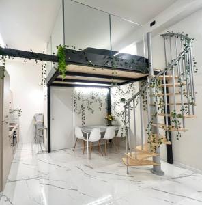 um quarto com uma mesa e cadeiras e uma escada em 0M Plant Turin em Turim