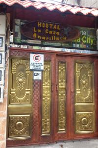 a store front with gold doors on a building at Hostal La Casa Amarilla City in Baños