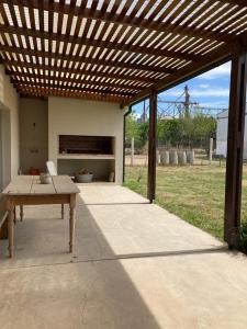 eine Terrasse mit einer hölzernen Pergola und einem Tisch in der Unterkunft La Casa de White in Colón