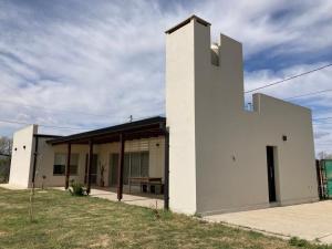 a white building with a table in front of it at La Casa de White in Colón Buenos Aires Province
