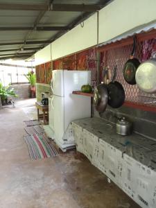 een keuken met een koelkast en enkele potten en pannen bij Ravehei smile relais 3 Huahine in Haapu