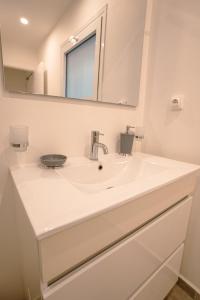 uma casa de banho com um lavatório e um espelho em Merveilleux studio cosy vue mer - piscine em São Martinho