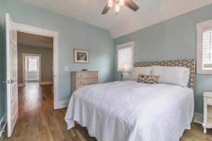 a bedroom with a white bed and blue walls at Newly Listed Duke St Cottage - Downtown Beaufort in Beaufort