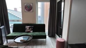 a living room with a green couch and a table at City Center Hotel in Reykjavík