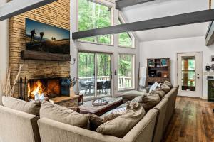a living room with a couch and a fireplace at Private Hideaway with Hot Tub - Stylish & Serene in Ellicottville