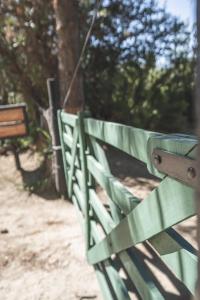 a green park bench sitting next to a fence at CABAÑA EL REMANSO in Villa Pehuenia