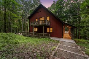 a red house in the middle of a forest at Private Hideaway with Hot Tub - Stylish & Serene in Ellicottville