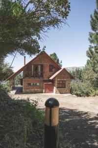 a small brick house in the middle of a road at CABAÑA EL REMANSO in Villa Pehuenia