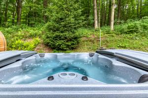 a hot tub in the middle of the woods at Beautiful chalet on 5 acres - 2 min to Village! Hot-Tub, Sauna, Fire Pit! in Ellicottville