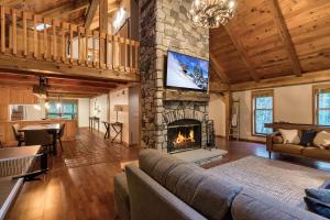 sala de estar con chimenea y TV en Beautiful chalet on 5 acres - 2 min to Village! Hot-Tub, Sauna, Fire Pit!, en Ellicottville