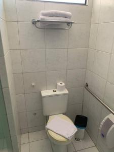a white bathroom with a toilet and a window at Flat Alto Padrão Beira Mar in Natal