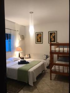 een slaapkamer met 2 bedden en een lamp bij Happy Guest House in Navegantes