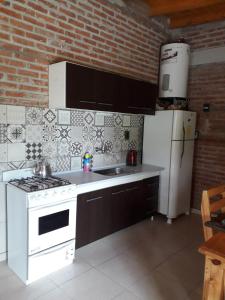 una cucina con piano cottura bianco e frigorifero di La casona del Paso a Paso de la Patria