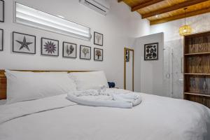 uma cama branca com um cobertor branco em 4 You Hotel Nosara em Playa Guiones