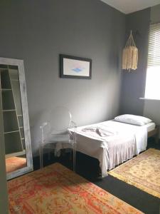 a bedroom with a bed and a mirror and a chair at Erva Cidreira Hostel in Salvador