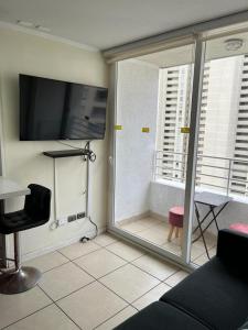 uma sala de estar com uma televisão de ecrã plano na parede em Lindo departamento a pasos de la playa em Coquimbo