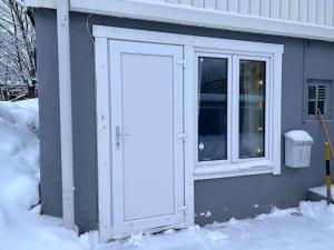 une porte menant à une maison dans la neige dans l'établissement Lägenhet med egen ingång., à Sundsvall